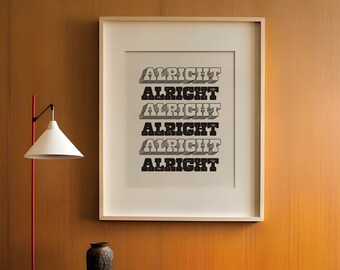 May include: A framed print with the word "ALRIGHT" stacked five times in a retro font hangs on a wood-panelled wall. A mid-century modern interior features a lamp, chair, and a low table with decor.