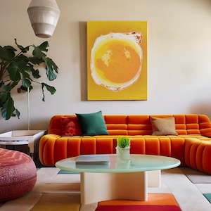 Puede incluir: Un salón moderno con un sofá de terciopelo naranja y cojines coloridos. Una mesa de centro redonda de cristal se encuentra sobre una alfombra estampada. Una pintura abstracta cuelga de la pared. Una gran planta y una lámpara decorativa completan la escena.