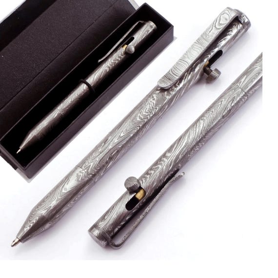 A Damascus steel ballpoint pen — the swirling forge patterns on something you'd use in a boardroom meeting is a gloriously absurd flex.