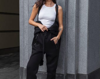 Warme stoffen damesjumpsuit met capuchon en bretels. Comfortabele winterjumpsuit voor dames. Casual jumpsuit van Morkva.