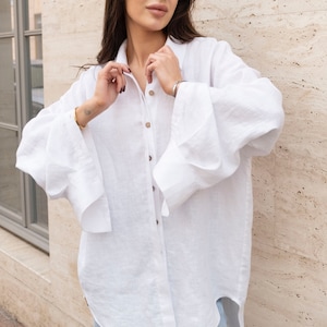 White women's long linen oversized shirt. Loose-fitting blouse made of washed linen. Loose women's linen shirt with wide sleeves