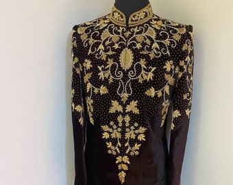 May include: A dark brown velvet kurta with gold embroidery featuring a floral design. The kurta has a mandarin collar and long sleeves.