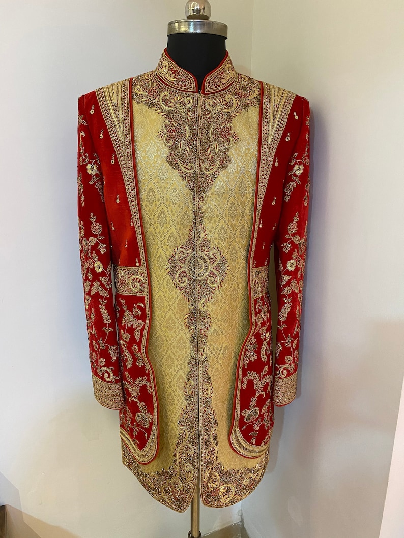 May include: A red and gold embroidered jacket with a mandarin collar. The jacket is decorated with intricate floral patterns and sequins.