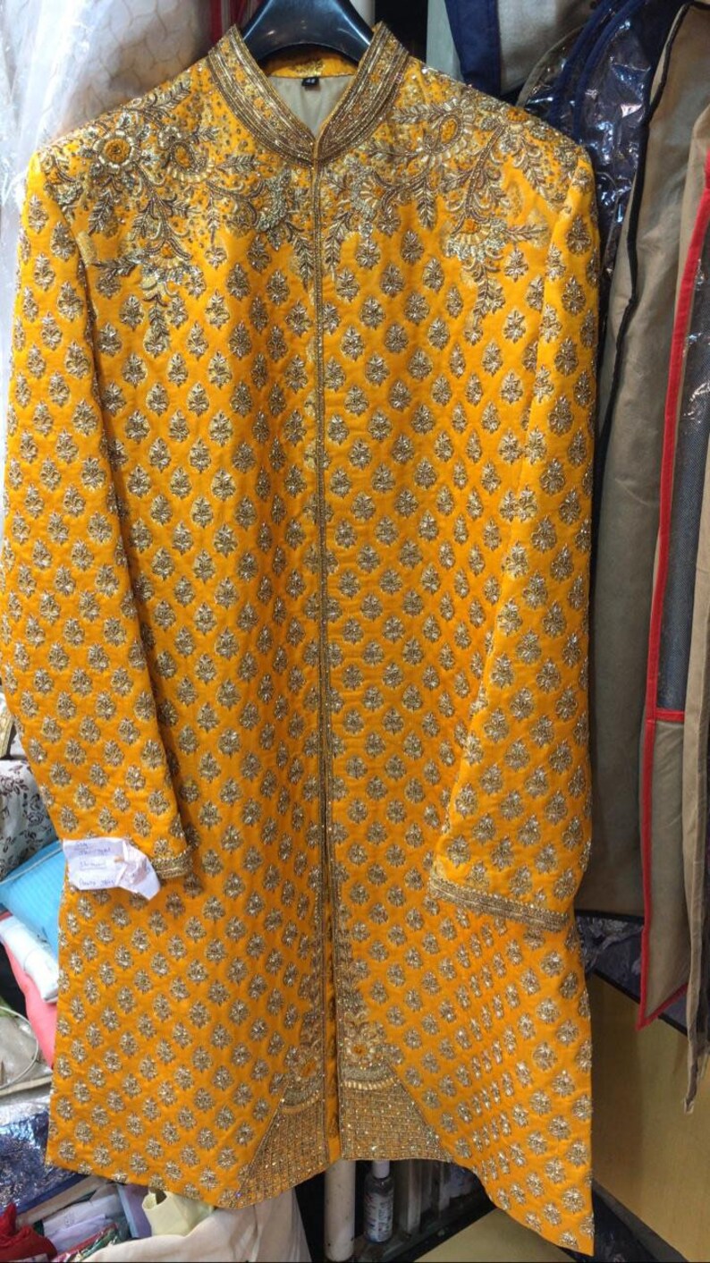 Może przedstawiać: Ż&oacute;łta kurta z haftem złotym. Kurta ma kołnierz mandaryński i długi, płynny kr&oacute;j. Tkanina jest miękka, luksusowa jedwab.
