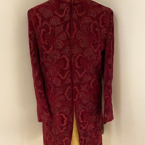 May include: A maroon velvet kurta with a floral pattern. The kurta has a mandarin collar and a long, flowing design.