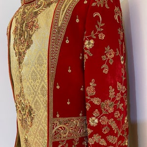 May include: A red and gold embroidered men's jacket with a mandarin collar. The jacket is decorated with intricate floral patterns and beading.