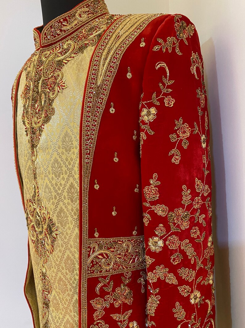 May include: A red and gold embroidered men's jacket with a mandarin collar. The jacket is decorated with intricate floral patterns and beading.