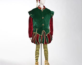 May include: A festive elf costume on a mannequin. The outfit includes a green velvet vest with gold trim and red sleeves, a matching red and green striped skirt, and black and yellow striped tights. The ensemble is completed with a red hat and gold elf shoes.