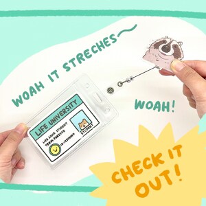 May include: A clear plastic ID badge holder with a retractable cord attached to a cartoon raccoon charm. The badge holder has a printed design that says "Life University" and "Life Long Student, Term Forever".