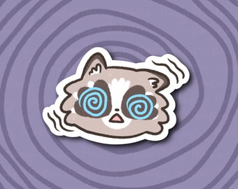 Puede incluir: Un mapache de dibujos animados con una cara blanca y ojos negros. Los ojos del mapache están girando con espirales azules y blancas. El mapache está rodeado por un contorno blanco y un fondo blanco.