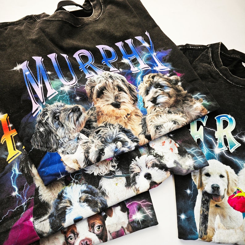 May include: Black t-shirt with a graphic print of dogs and the word "MURPHY" in white letters. The dogs are various breeds and colors, including brown, black, and white. The background is a dark blue and purple galaxy print with lightning bolts.