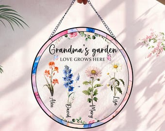 May include: A round stained glass window hanging with a pink, blue, and white floral design. The text "Grandma's garden LOVE GROWS HERE" is printed on the window. The names Alex, David, Mary, and Lisa are printed below the flowers.