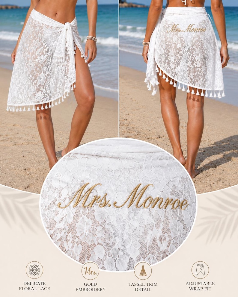 May include: A white lace sarong wrap featuring a delicate floral pattern, a tassel-trimmed hem, and gold embroidery on the back that reads "Mrs. Monroe." The garment is designed with an adjustable wrap fit for versatile styling over swimwear.