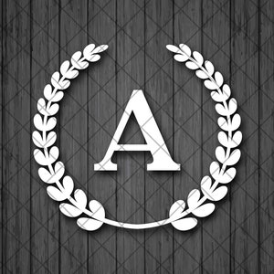 Può includere: Lettera A bianca circondata da una corona di alloro bianca su uno sfondo di legno scuro.