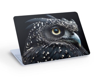 May include: A close-up of a black and white owl with a yellow eye. The owl's head is turned to the side, and its feathers are ruffled. The background is black.
