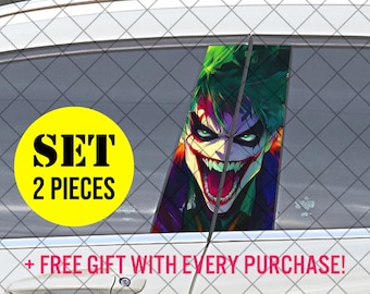 Op de afbeelding: Een set autostickers met een levendige illustratie van de Joker met groen haar en een grijnzende mond. De afbeelding staat op een autoruit, met een gele cirkel met de tekst "SET 2 PIECES".