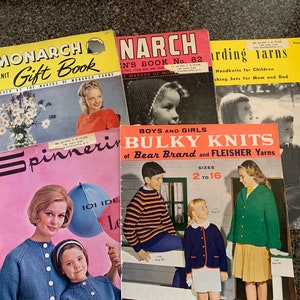 May include: A collection of vintage knitting pattern books with colourful covers featuring knitwear designs for children and adults. The books are titled "Monarch Hand Knit Gift Book", "Narch", "Spinner", and "Bulky Knits of Bear Brand and Fleisher Yarns".