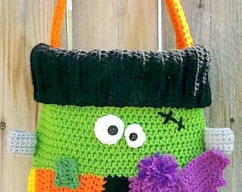 May include: A crocheted Halloween trick-or-treat bag shaped like a Frankenstein monster with a purple bat attached. The bag has a black, green, orange, and yellow color scheme.