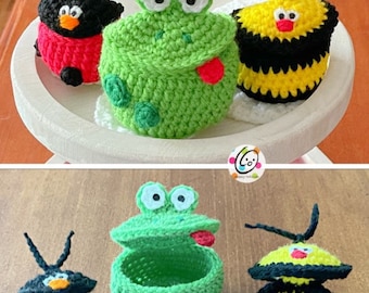 May include: Three crocheted animal-shaped boxes with lids. The boxes are a ladybug, a frog, and a bee. The ladybug is red with black spots, the frog is green with white eyes, and the bee is yellow and black.