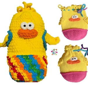 Peut inclure: Trois peluches de canard jaunes en crochet. Le plus grand canard a un bas rayé arc-en-ciel et un sac à dos bleu. Les deux plus petits canards ont un bas rose.
