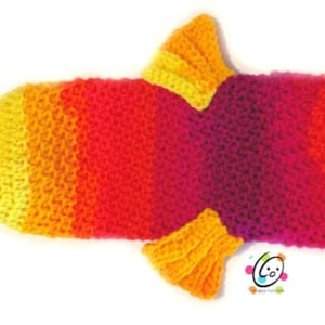 May include: A crocheted fish toy with a bright orange, yellow, and pink color scheme. The fish has large white eyes with black pupils and a yellow crocheted fin on each side.