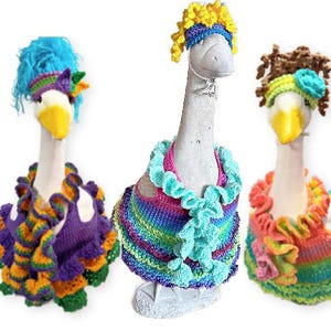 Può includere: Cinque statuette di oche vestite con abiti all'uncinetto colorati fatti a mano. Ogni oca ha un becco giallo ed è adornata con una parrucca diversa e un copricapo abbinato. Gli abiti presentano colori vivaci come viola, blu, arancione e verde.