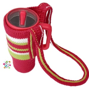 Könnte beinhalten: Eine rote gehäkelte Becherhülle mit einem grün-weiß gestreiften Muster. Die Hülle hat einen langen Trageriemen.