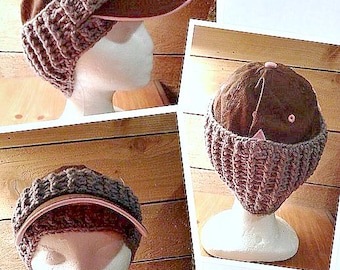 May include: A brown baseball cap with a crocheted brim. The cap has a pink underside and a white button on top. The cap is displayed on a white mannequin head.