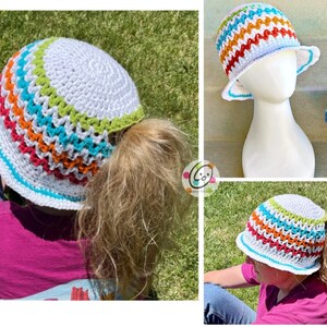 May include: A white crochet bucket hat with a colorful striped band. The hat has a hole in the back for a ponytail.