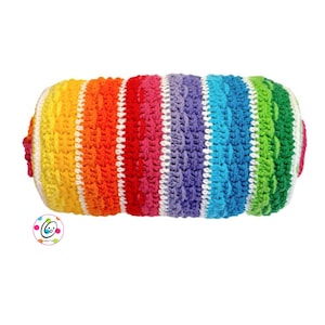 Könnte beinhalten: Ein zylindrisches Häkelkissen in Regenbogenfarben. Das Kissen hat vertikale Streifen in Gelb, Orange, Rot, Pink, Lila, Blau und Grün. Die Enden sind weiß mit rosa Akzenten. Das Häkelmuster ist ein strukturiertes Zopfmuster.