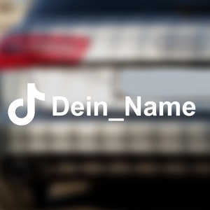 Könnte beinhalten: Ein silbernes Auto mit einem weißen TikTok-Logo und dem Text "Dein_Name" auf der hinteren Stoßstange.