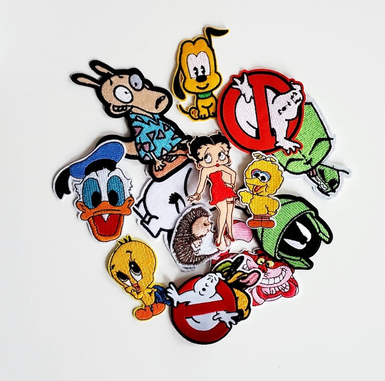 Puede incluir: Una colecci&oacute;n de parches bordados con personajes de dibujos animados como el Pato Donald, Betty Boop y Big Bird. Los parches son coloridos e incluyen personajes de varias series y pel&iacute;culas de animaci&oacute;n.