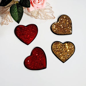 May include: Four heart-shaped patches, two red and two gold, with a sparkly sequin design.