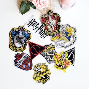 Puede incluir: Un conjunto de parches bordados con dise&ntilde;os de la serie Harry Potter. Los parches incluyen los escudos de las casas de Hogwarts: Gryffindor, Ravenclaw, Hufflepuff y Slytherin, junto con un parche que dice "Harry Potter" y el s&iacute;mbolo de las Reliquias de la Muerte.