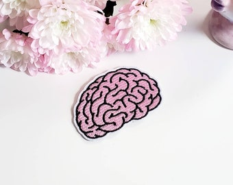 May include: Pink embroidered brain patch with black outline. The patch is on a white background.