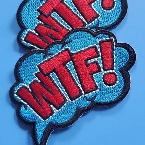 May include: Two blue and black embroidered patches with white outlines. The patches are shaped like speech bubbles and say "WTF!" in red letters.