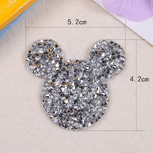 May include: A silver rhinestone Mickey Mouse design iron-on patch, measuring 5.2 cm wide and 4.2 cm tall.
