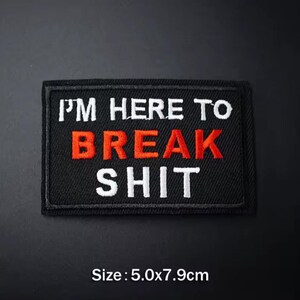 May include: Black rectangular embroidered patch with the text "I'M HERE TO BREAK SHIT" in white and red thread. The patch measures 5.0 x 7.9 cm.