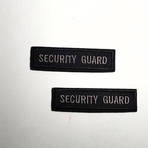 May include: Two black rectangular patches with white embroidered text that reads "SECURITY GUARD".