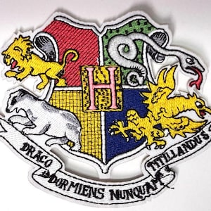 May include: Embroidered Hogwarts crest patch. The crest is divided into four sections, each with a different animal: a lion, snake, badger, and eagle. The patch includes the Latin phrase "Draco Dormiens Nunquam Titillandus" on a banner.