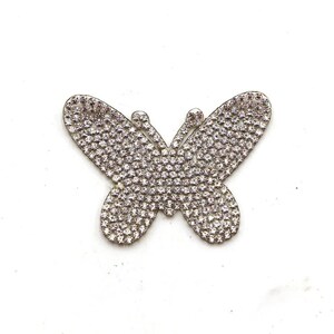 May include: A silver butterfly-shaped embellishment covered in clear rhinestones.