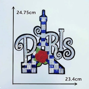 以下が含まれることがあります： エッフェル塔と「Paris」の文字が特徴的なスパンコールパッチ。塔は青と白で、基部には赤いバラがあります。パッチの幅は23.4cm、高さは24.75cmです。