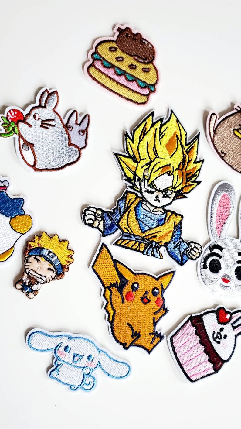 Puede incluir: Colecci&oacute;n de parches bordados con varios personajes de dibujos animados y alimentos. Los parches incluyen una hamburguesa, un personaje con pelo amarillo, un Pikachu amarillo, un personaje azul y una magdalena con un coraz&oacute;n.