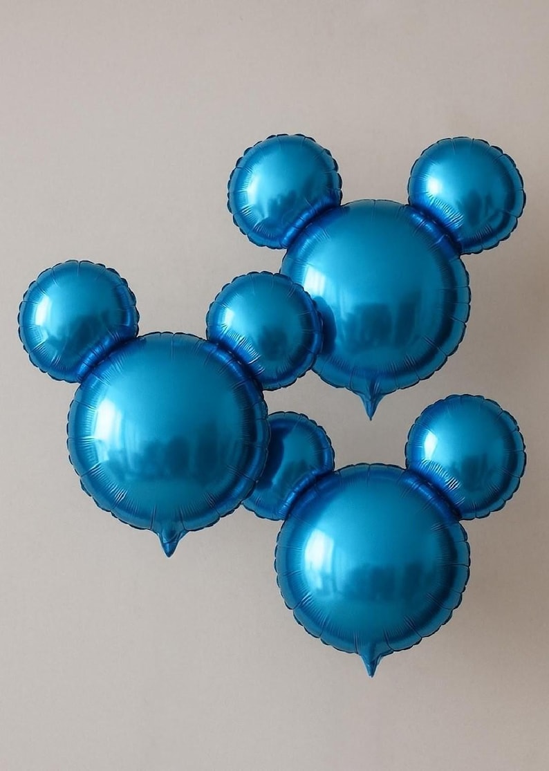 Puede incluir: Tres globos azules de papel de aluminio con forma de cabeza de rat&oacute;n y dos orejas redondas. Los globos brillantes son de un azul vivo y est&aacute;n colocados sobre un fondo blanco liso. Adecuados para una fiesta de cumplea&ntilde;os u otra celebraci&oacute;n.