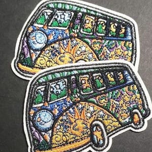 May include: Two colorful embroidered patches of a psychedelic Volkswagen van with a sun and moon design. The patches are on a dark gray background.
