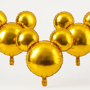 Puede incluir: Varios globos dorados con forma de cabeza de rat&oacute;n. Los globos son redondos y tienen un acabado met&aacute;lico brillante. Estos globos inflados son adecuados para una fiesta o celebraci&oacute;n.