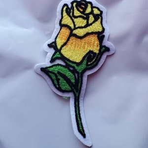 Stickad broderad sy-på-lapp med gul ros