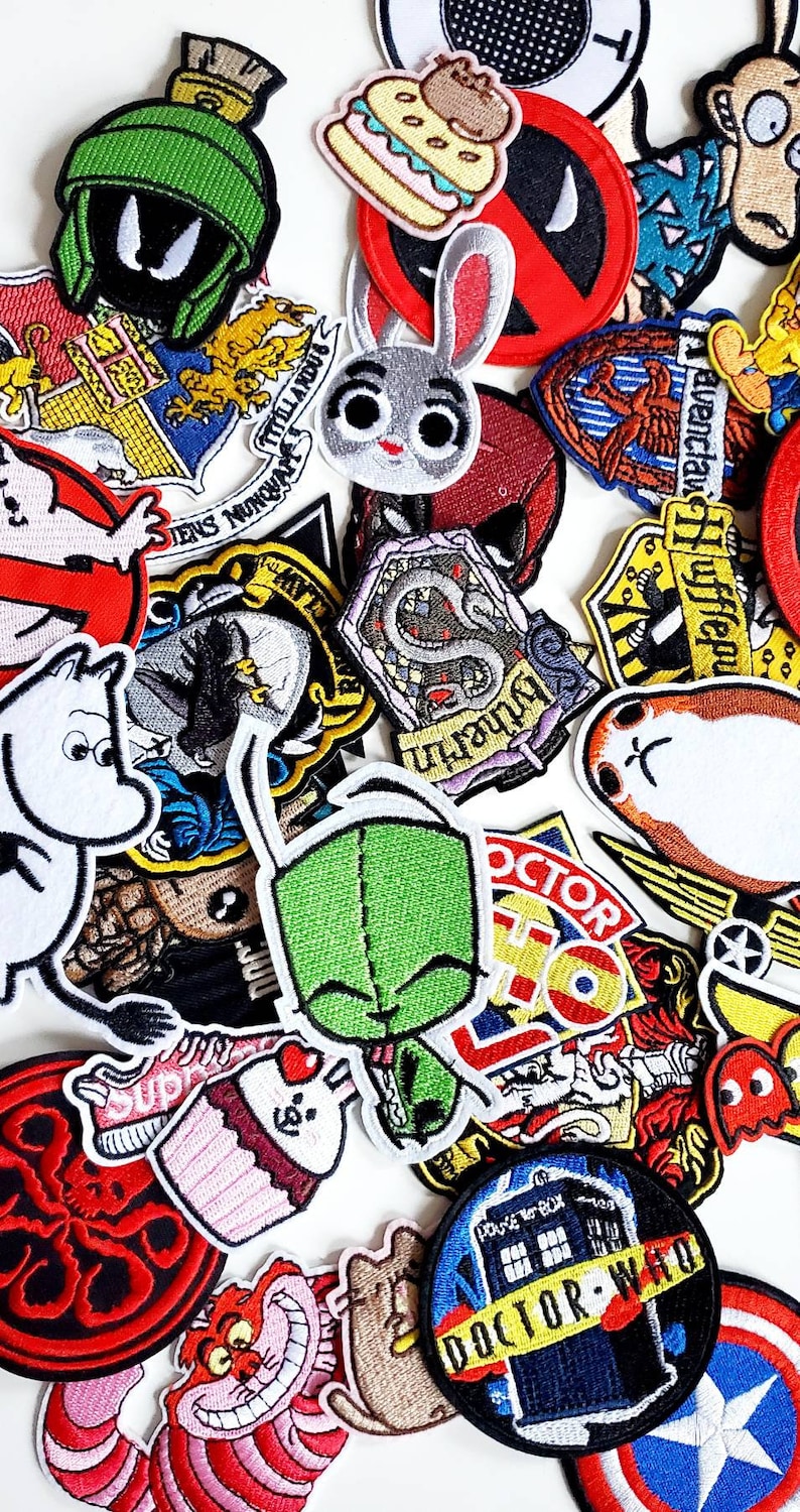 Puede incluir: Una colecci&oacute;n de parches bordados coloridos con personajes de dibujos animados y referencias a la cultura pop. Los dise&ntilde;os incluyen un extraterrestre verde, un conejo, una magdalena y la TARDIS de Doctor Who. Los parches son de varias formas y tama&ntilde;os.