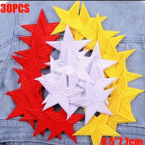 Puede incluir: Un conjunto de parches de estrellas bordadas en rojo, blanco y amarillo. Los parches son de varios tamaños y están colocados sobre una chaqueta vaquera. El texto "30PCS" es visible. Las dimensiones son 8,5 cm por 7,7 cm.