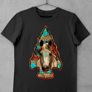 May include: Black t-shirt featuring a colourful graphic of a horse's head within an arrowhead. The arrowhead is filled with geometric patterns and animal print.